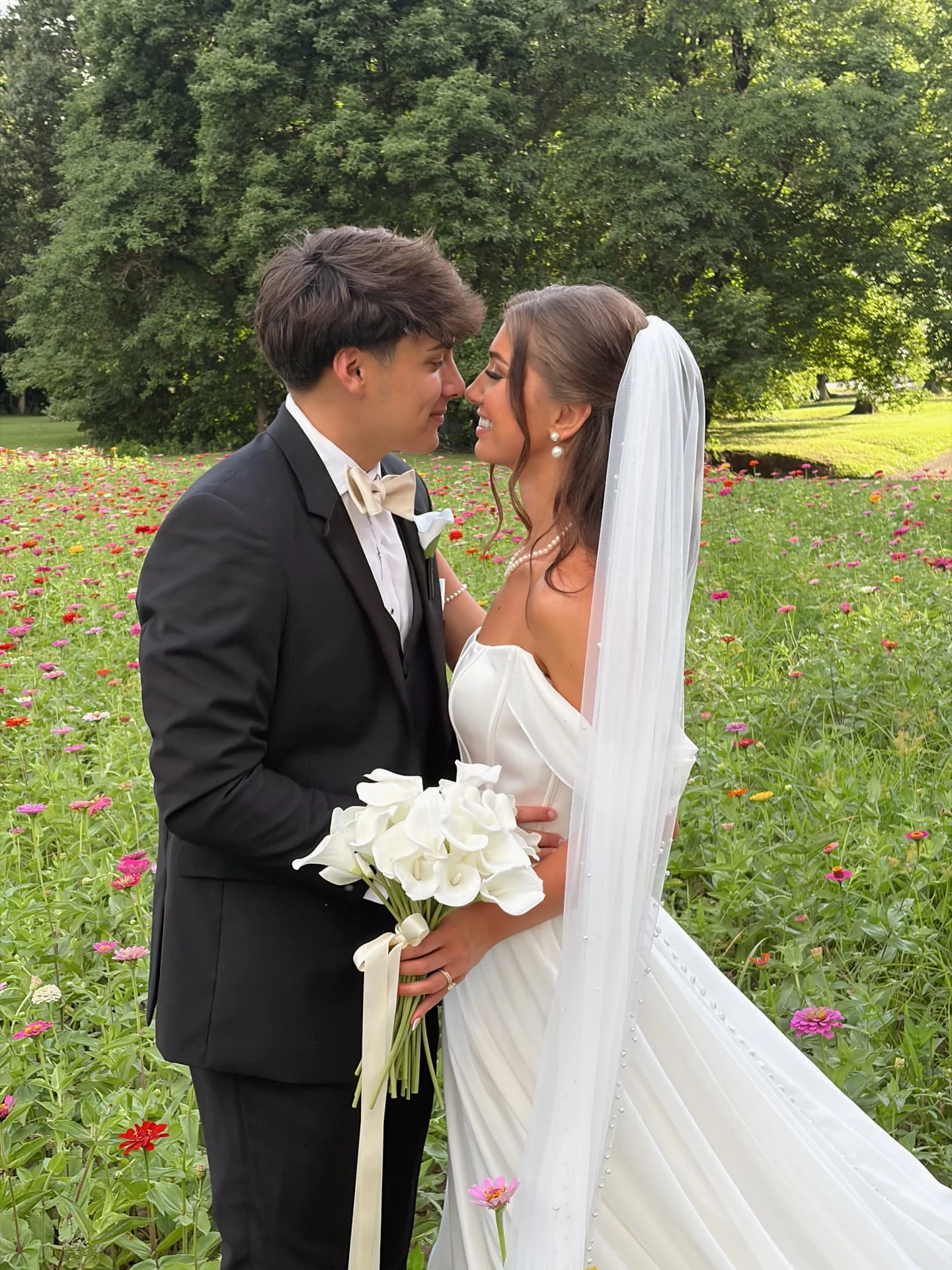 Bride and groom holding a white bouquet together in a garden